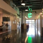 Hlevel Architecture-Pyure Corporate Campus interior view of Garage doors with green neon light sign